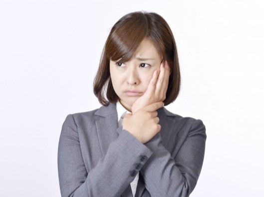 頬を押さえる女性