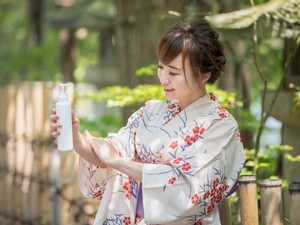虫除けスプレーする女性